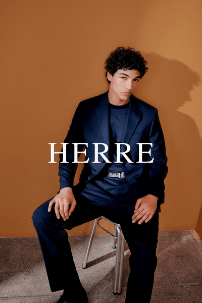 Herre banner med modell i dress sittende på krakk mot ensfarget bakgrunn