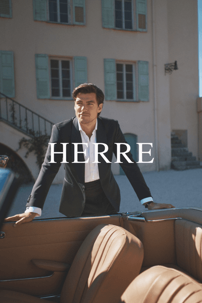 Modell i dress og skjorte fra Oscar Jacobson, stående ved bil utendørs